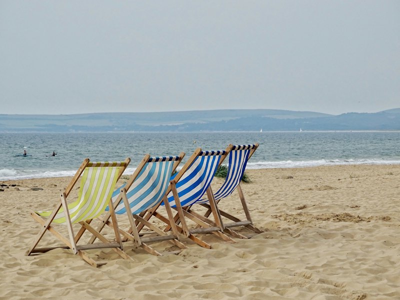 Striped deckchairs lined up on a beach