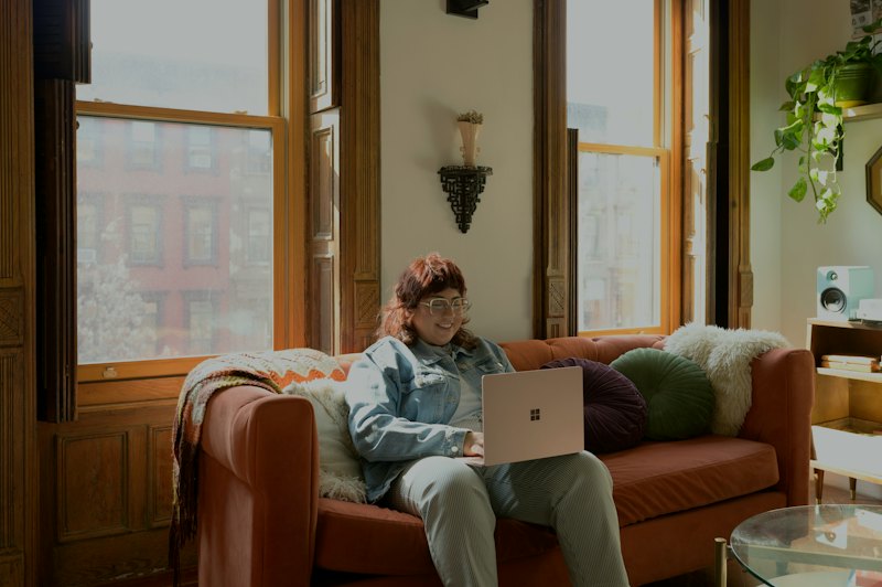 Someone working on a laptop from a sofa at home